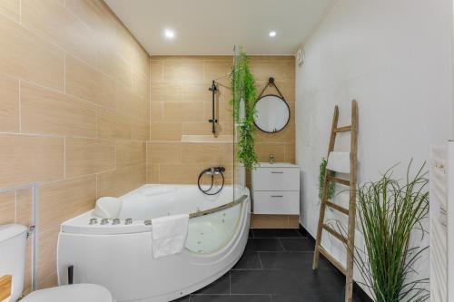 a bathroom with a tub and a toilet and a sink at Nid Amour Cabane et Spa Privatif in Rouen