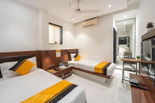 a hotel room with two beds and a bathroom at Glitz Rexton Inn - Near IIT Powai in Mumbai