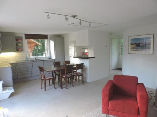 eine Küche und ein Esszimmer mit einem Tisch und Stühlen in der Unterkunft Bungalow Veluwemeer in Ermelo