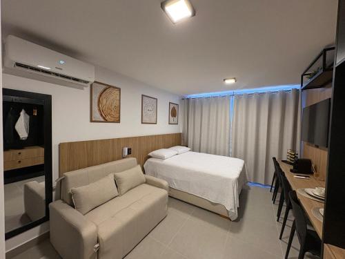 a hotel room with a bed and a couch at Flat Praia Ponta de Campina in Cabedelo