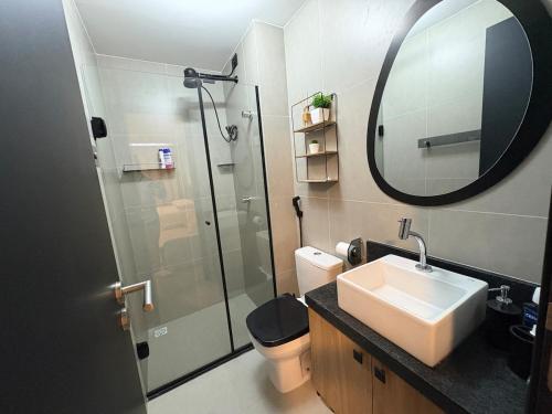 a bathroom with a sink and a shower with a mirror at Flat Praia Ponta de Campina in Cabedelo
