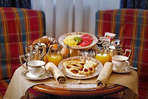 a breakfast table with plates of food and drinks at Hotel Capitol Milano in Milan