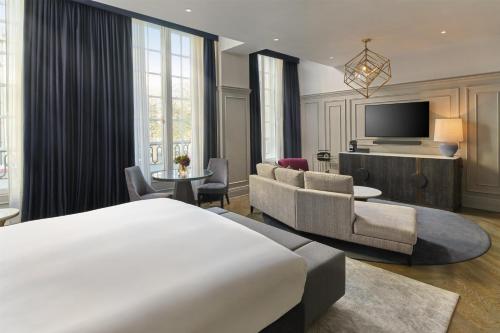 a hotel room with a bed and a tv at The Trafalgar St James London Curio Collection by Hilton in London