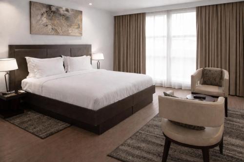 a hotel room with a bed and a chair at DoubleTree by Hilton Nairobi in Nairobi