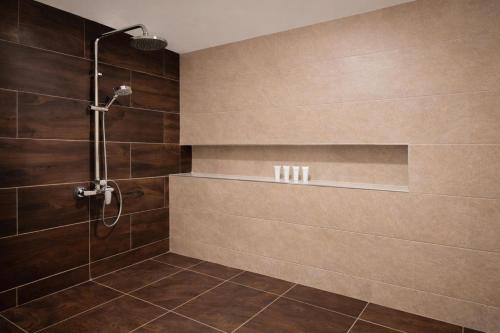 a bathroom with a shower with brown tiles at DoubleTree by Hilton Nairobi in Nairobi