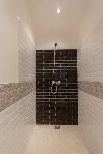 a bathroom with a shower with a brick wall at Luxury Apartment by Hi5-Városház Suite in Budapest