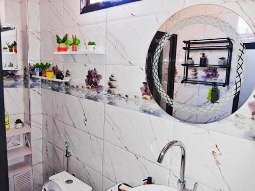 a bathroom with a sink and a mirror at Résidence Atlantis F2 avec balcon vue dégagée in Dakar