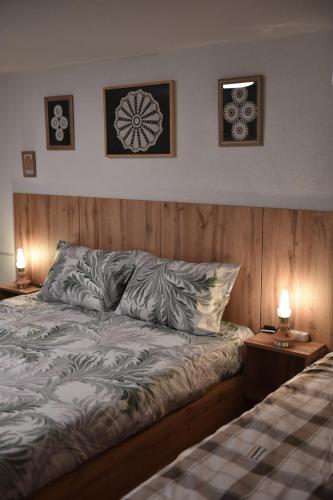 a bed in a bedroom with two lamps on tables at Lex Apartments KS in Prizren