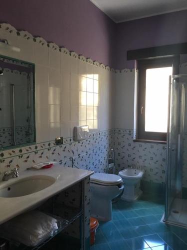 a bathroom with a sink and a toilet and a window at Il casolare in Borgia