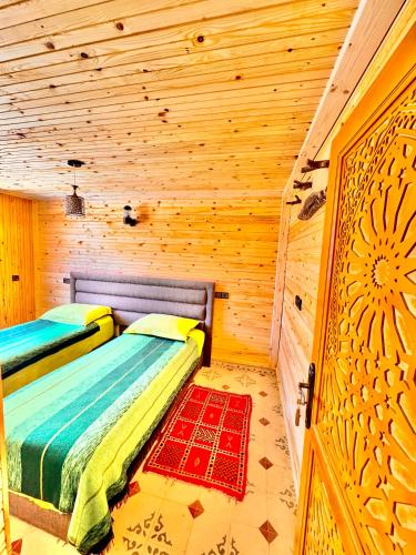 a bedroom with a bed in a log cabin at Atlas Chalet Armed in Imlil