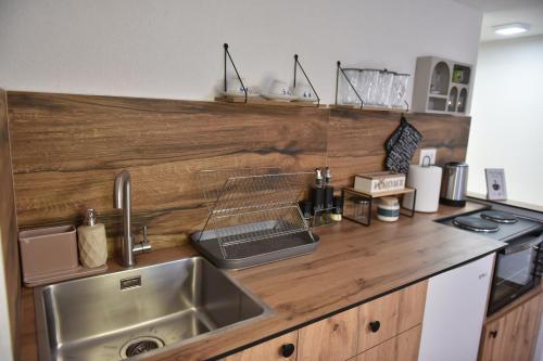 a kitchen with a sink and a wooden counter top at Lex Apartments KS in Prizren