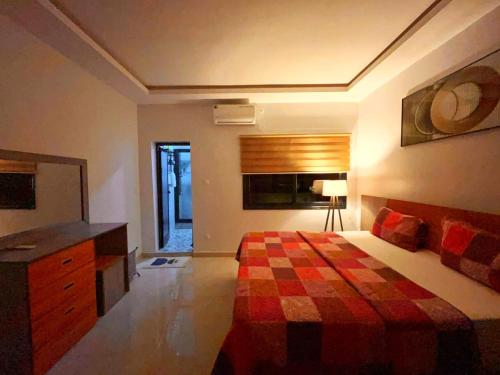 a bedroom with a bed with a checkered blanket at Résidence Atlantis F2 avec balcon vue dégagée in Dakar