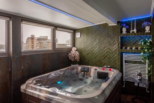 a large bath tub in a room with windows at Crystal Luxury in Craiova