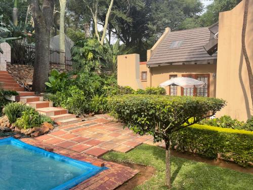 a backyard with a swimming pool and a house at Lalakamnandi Guesthouse in Pretoria