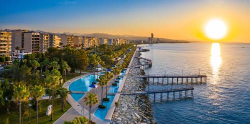 an aerial view of a city and the ocean at sunset at SEAFRONT 1BDR, Panoramic views, central Marina in Limassol