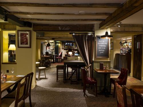 um restaurante com mesas e cadeiras e um bar em The Springfield Inn by Innkeeper's Collection em Lowdham