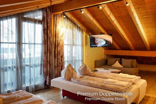 a room with a bed and a large window at Landhotel Guglhupf in Schwangau