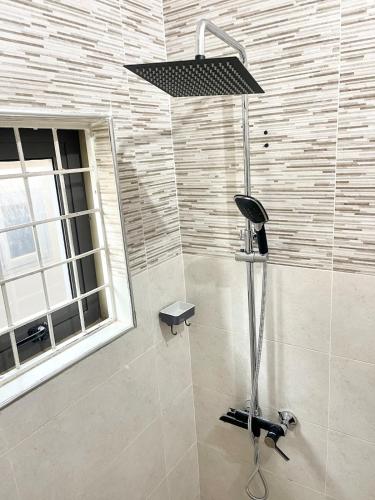 a shower with a shower head in a bathroom at Imaani Homes - 2A at JAK Royale in Apenkwa