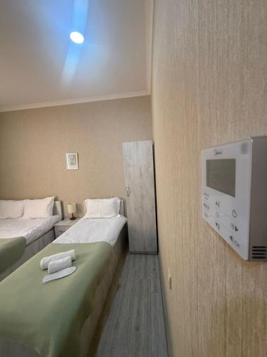 a hotel room with two beds and a tv at Hotel Blue sky in Tbilisi City