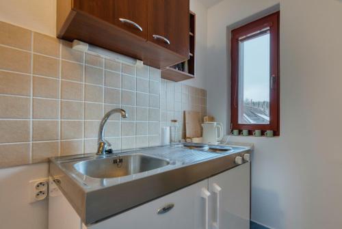 a kitchen with a sink and a window at Resort Levočská Dolina in Levoča