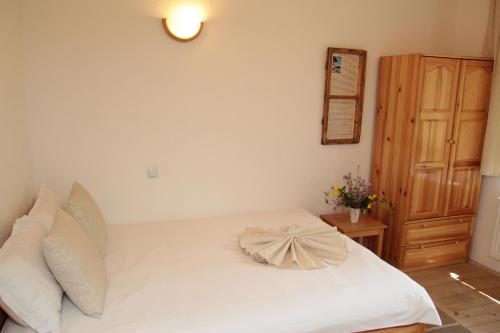 a bed with white sheets and pillows in a bedroom at Арт комплекс Горски дом - Трявна in Tryavna