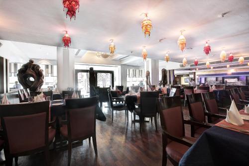 a dining room with tables and chairs and chandeliers at Western Court Panchkula in Chandīgarh