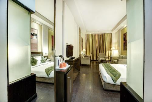 a hotel room with two beds and a living room at Western Court Panchkula in Chandīgarh