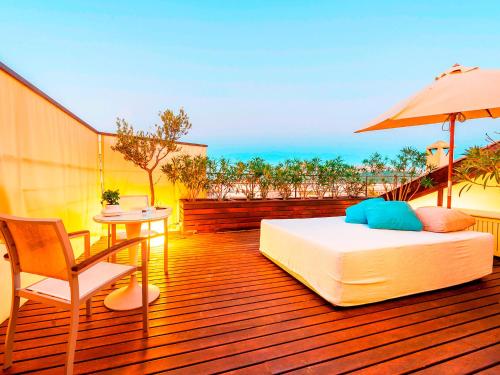 a bedroom with a bed and an umbrella on a deck at Cas Ferrer Nou Hotelet in Alcudia