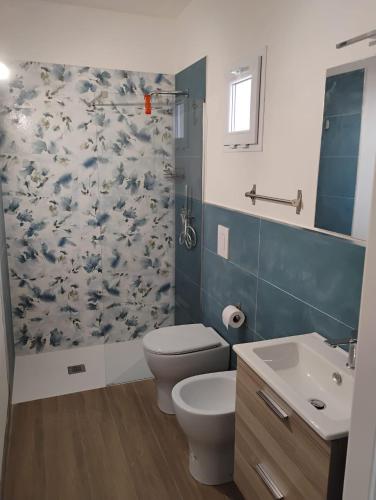 a bathroom with a toilet and a shower curtain at Dentro Scopello - Casa Vacanze in Scopello