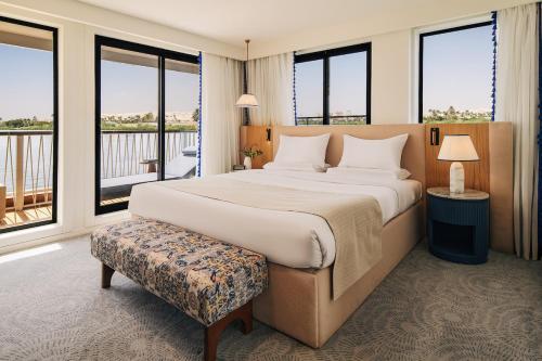 a bedroom with a large bed and a balcony at Mazaj Meroot Dahabiya - Every Monday from Luxor in Luxor