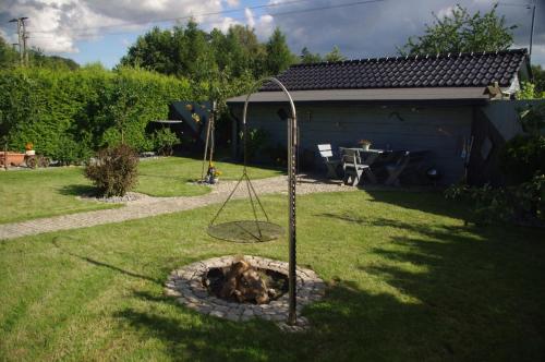a playground in a yard with a swing at Dom z widokiem na jezioro i domek nad jeziorem in Łapalice