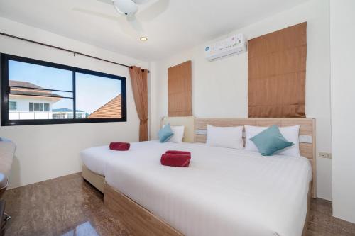 a bedroom with a large white bed and a window at Rawai 3BR Villa Shared Pool near Shops & Dining in Ban Saiyuan (1)
