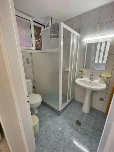a bathroom with a toilet and a sink at Eleni's Cottage in Fiskardo