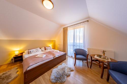 a bedroom with a bed and a chair and a table at Resort Levočská Dolina in Levoča