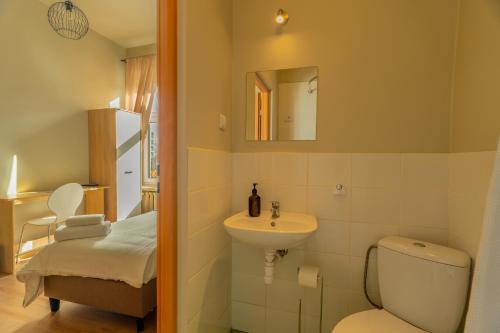 a bathroom with a sink and a toilet and a mirror at Hostel H360 - dawniej Hotelik Relax in Łódź