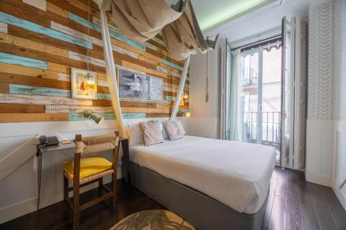 a bedroom with a bed and a desk with a chair at Abalú Collection Hotel Life Gran Via in Madrid