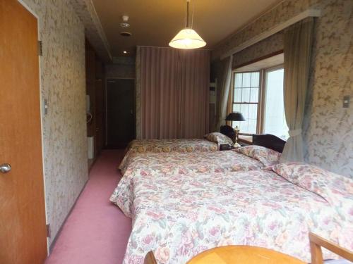 a bedroom with two beds and a window at Naeba Springs Hotel in Yuzawa