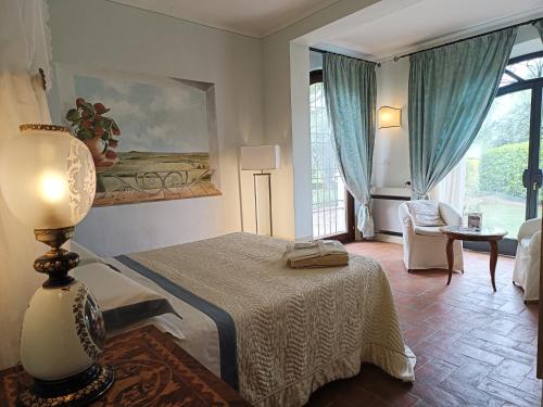 a bedroom with a bed and a table with a lamp at Villa La Valiana - Full Estate in Montepulciano - HEATED POOL in Valiano