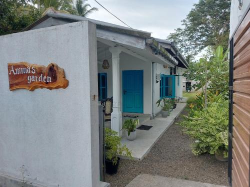 a building with blue doors and a sign on it at Amma's Garden in Unawatuna