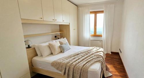 a white bedroom with a bed with a blanket on it at Appartamenti Vista Lago - Costermano sul Garda - Be Happy! in Costermano sul garda