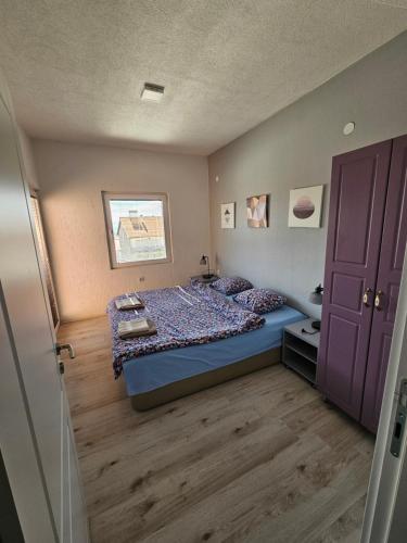 a bedroom with a bed and a purple cabinet at Markos Towers Apartments in Prilep