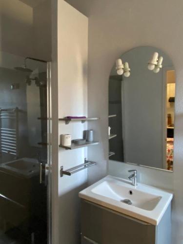 a bathroom with a sink and a mirror and a tub at Villa MERYEM in Néris-les-Bains