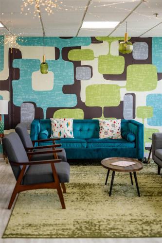 a living room with a blue couch and a table at The Bethesdan Hotel, Tapestry Collection by Hilton in Bethesda