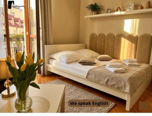 a bedroom with a large bed with a vase of flowers at Apartamenty Przemyśl in Przemyśl