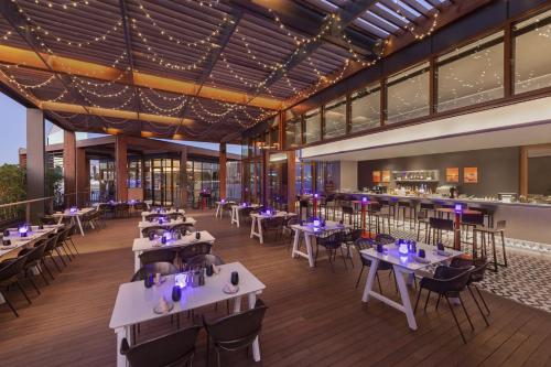 a rendering of a restaurant with tables and chairs at Canopy by Hilton Dubai Al Seef in Dubai