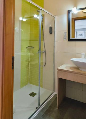 eine Glasdusche in einem Badezimmer mit Waschbecken in der Unterkunft Hotel Nobu Peniche in Peniche