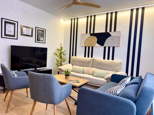 a living room with blue chairs and a couch at Oak Lodge - Oakplaces in León