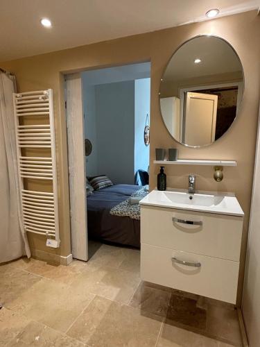 a bathroom with a sink and a mirror and a bed at Les Capucins de Provins Studio in Provins