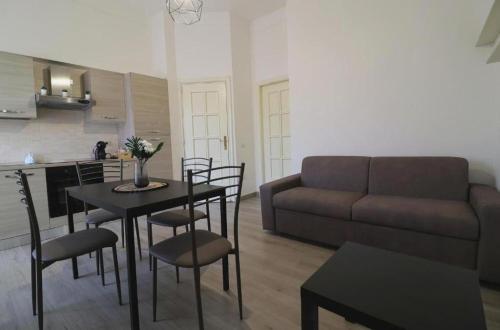 a living room with a couch and a table and chairs at Pompei Centro Apartments in Pompei