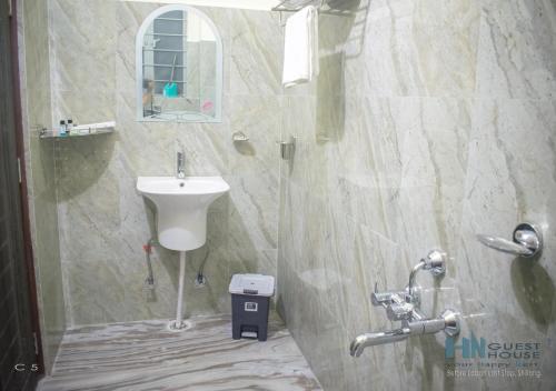 a bathroom with a sink and a toilet and a mirror at HN Guest House in Shillong